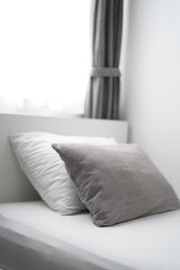 a pillow sitting on a bed with a window at Apartments Loncar-near Zrće beach in Novalja