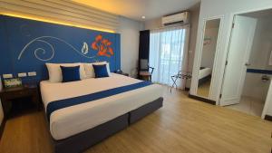 a bedroom with a large bed with a blue wall at Days Inn by Wyndham Patong Beach in Patong Beach