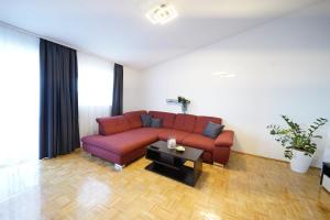 a living room with a red couch and a coffee table at Apartments Loncar-near Zrće beach in Novalja