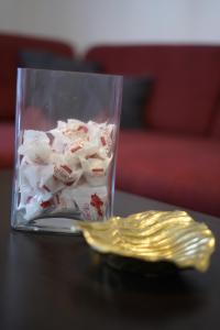 a glass container filled with marshmallows and a gold fork at Apartments Loncar-near Zrće beach in Novalja