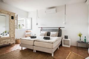 a bedroom with a large bed and a bathroom at Casa Kalu in São Brás de Alportel