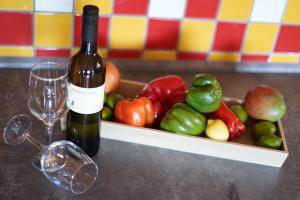 a bottle of wine next to a box of fruit and vegetables at Apartments Loncar-near Zrće beach in Novalja