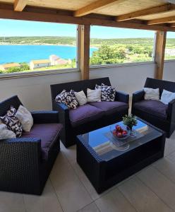 a living room with two couches and a table at Apartments Loncar-near Zrće beach in Novalja