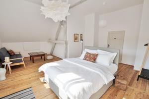 a bedroom with a bed with white sheets and a chandelier at Rajskie Jabłka - azyl dla dorosłych in Lubomierz