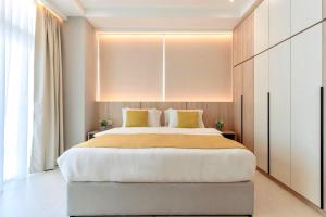 a bedroom with a large white bed with yellow pillows at Riverine Diamond Kuching in Kuching