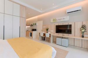 a large bedroom with a large bed and a kitchen at Riverine Diamond Kuching in Kuching