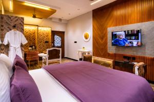 a bedroom with a bed and a tv on a wall at Dream Connect Boutique House in Jodhpur