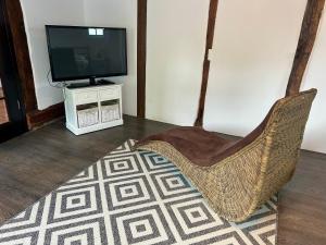 un salon avec une télévision et une chaise dans l'établissement Charmantes Haus Nähe Bonn Köln Messe Phantasialand, à Bornheim