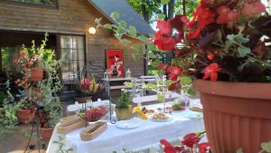 a table with a white table cloth and potted plants at Jumpravmuiža in Jumprava