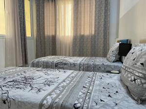 a bedroom with two beds and a window at Mahdia Appartement in Mahdia