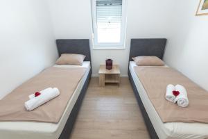 two beds in a room with towels at Sea&Sand Apartment - Modern Sea View near Sandy Beaches in Privlaka +58 photos