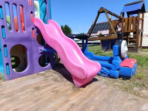 a pink slide on a playground with a swing at Domki u Rybaka Wapnica in Wapnica