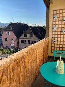 eine Terrasse mit einem grünen Tisch und einem Zaun in der Unterkunft Appartement Centre Alsace in Gertwiller