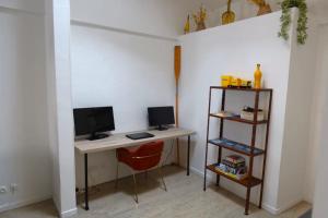 a room with a desk with a computer and a shelf at Le Refuge du Port, parking privé gratuit in La Ciotat
