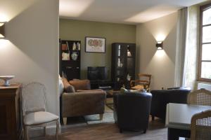 a living room with a couch and chairs and a tv at Maison Lambert in Domme