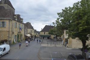 a group of people walking down a street in a town at Maison Lambert in Domme