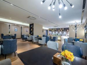 a restaurant with blue chairs and tables and a bar at Echarm Hotel Nanning the MixC Exhibition Center Metro Station in Nanning