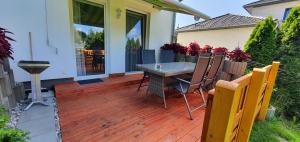 a wooden deck with a table and chairs on a house at Fewo Traum in Neppermin