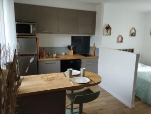 a small kitchen with a wooden table in a room at Studio pour 2 personnes avec jardin in Trémuson