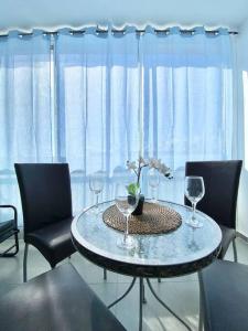 a dining room table with two chairs and wine glasses at Deluxe near the Mediterranean in Haifa
