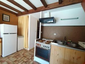 a kitchen with a stove and a sink and a refrigerator at Maison à 150 m Plage 6LT221 in Saint Pierre La Mer