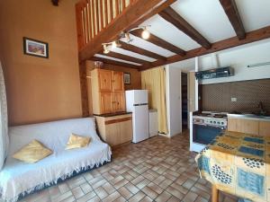 a kitchen with a white bed in a room at Maison à 150 m Plage 6LT221 in Saint Pierre La Mer