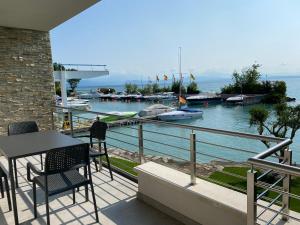 a balcony with a table and chairs overlooking a marina at Sirmio Apartments - Darsena Stay in Sirmione