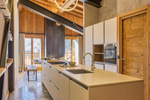 a kitchen with white cabinets and a wooden ceiling at La Ferme à Roland Cozy Mountain Style 2BR for 6 Ski In/Ski out - Happy Rentals in Chamonix