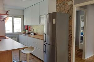 a stainless steel refrigerator in a kitchen with white cabinets at Apartamento San Juan de la Arena Asturias España in San Juan de la Arena