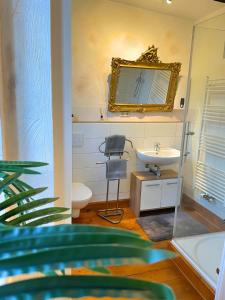 un bagno con lavandino e specchio di Monteurwohnungen - Pension Am Schloss a Teistungen Altre 52 foto