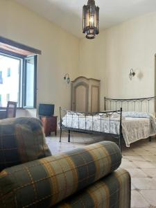 a bedroom with a bed and a couch and a chair at Casaulmi in Otranto