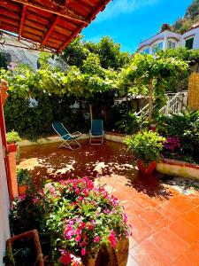 a patio with a bunch of flowers and chairs at L'orchidea del faro in Miseno