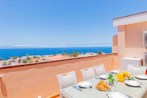 a table and chairs on a balcony with a view of the ocean at Penthouse Apt With Jacuzzi By Dream Homes Tenerife in Puerto de Santiago