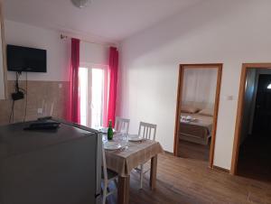a kitchen with a table and a dining room at Apartmani Peko in Pag