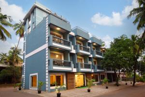 a blue building with trees in front of it at The Hawaii Comforts Panjim in Panaji +37 photos