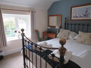 a bedroom with a bed and a mirror and a window at Ganton Greyhound Inn in Ganton