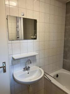 a bathroom with a sink and a mirror and a tub at Huisje voor Rust, Ruimte en Natuur in Neede +4 photos