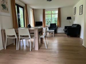 a living room with a wooden table and chairs at Huisje voor Rust, Ruimte en Natuur in Neede