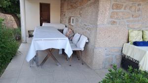 a table and chairs on a patio with a stone wall at Casa do Vicente in Tabuaço