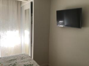 a bedroom with a tv on the wall and a bed at Mi lugar de vacaciones in Miño