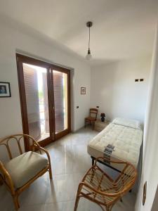 a bedroom with a bed and a chair and a window at Appartamento estivo Tortoreto Lido prima fila in Tortoreto Lido