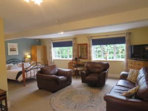 a living room with a bed and a couch and chairs at Ganton Greyhound Inn in Ganton