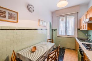 a kitchen with a table and a clock on the wall at Sestri Levante Acquamarina in Sestri Levante +35 photos