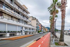 an empty street with palm trees and buildings at Sestri Levante Acquamarina in Sestri Levante