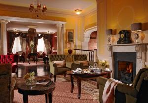 a living room filled with furniture and a fireplace at Buswells Hotel in Dublin