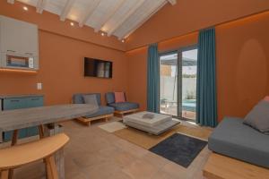 a living room with orange walls and a table and chairs at Tessera Boutique Hotel & Villas Collection in Gouvia