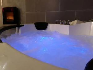 une baignoire remplie d'eau bleue dans une salle de bain dans l'établissement Charmant studio à Baixas de 30 m² avec Jacuzzi, à Baixas