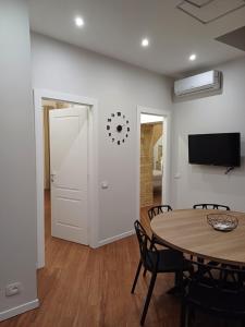 a dining room with a table and a tv at Residenza del Massimo in Palermo