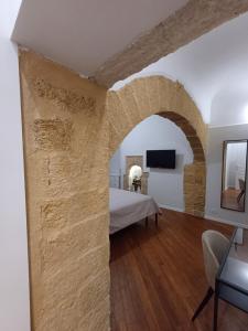 a bedroom with a stone wall and a bed at Residenza del Massimo in Palermo