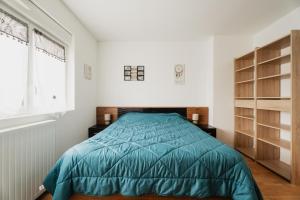 a bedroom with a bed with a blue comforter at Maison des Clos Biais in Dinard